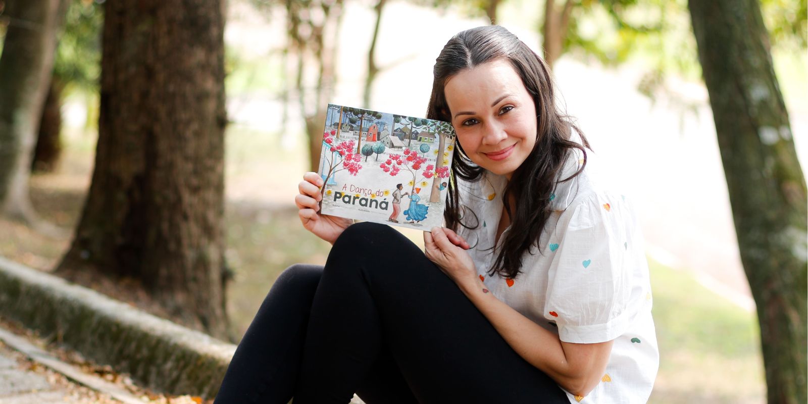 Marcele Martins com livro A Dança do Paraná. Foto: Divulgação.